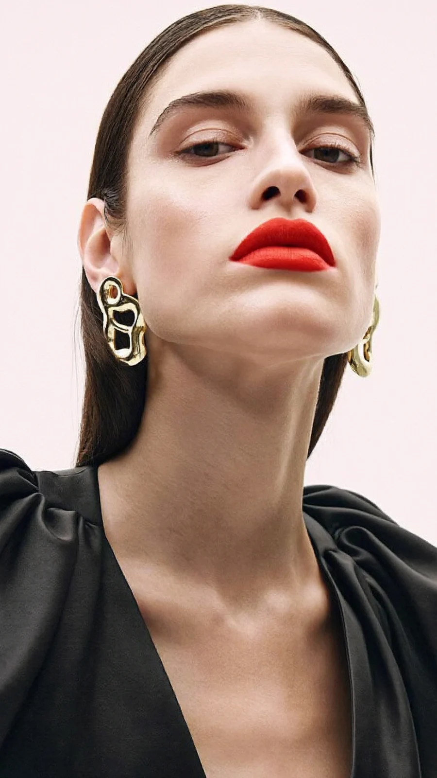Moda: rossetto rosso e orecchini scultura, abito nero